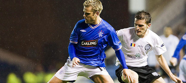 El jugador Jerome Rothen de los Rangers lucha por el bal&oacute;n con Marius Bilasco del Unirea Urziceni.