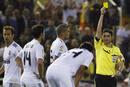 Real Madrids Xabi Alonso receives a yellow card during their Kings Cup final soccer match against Barcelona at Mestalla stadium in Valencia
