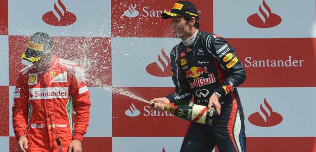Red Bull Formula One driver Mark Weber of Australia (R) sprays Ferrari Formula One driver Fernando Alonso after winning the British F1 Grand Prix at Silverstone, central England