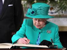 La reina Isabel II firma el libro de visitas de la residencia presidencial de Irlanda