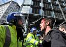 Un manifestante herido discute con un agente despu&eacute;s de una carga policial en Londres.