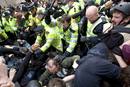 Agentes de polic&iacute;a cargan contra un grupo de manifestantes en Londres.