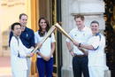 El duque y la duquesa de Cambridge y el pr&iacute;ncipe Enrique observan el relevo de la antorcha ol&iacute;mpica de Londres 2012 entre Wai-Ming y John Hulse en el palacio de Buckingham en Londres (Reino Unido).