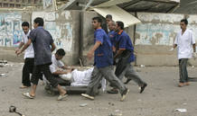 Rescuers take a wounded woman to the nearest hospital after two car bombs targeting the Ministry of Justice and the Baghdad Provincial Council exploded in central Baghdad