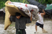 Residents of the Flor del Campo neighbourhood evacuate with their belongings due to the overflowing Choluteca River following heavy rains in Tegucigalpa Residents of the Flor del Campo neighbourhood evacuate with their belongings due to the overflowing Choluteca River following heavy rains in Tegucigalpa