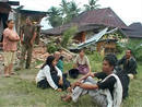 Residents wait outside damaged houses after an earthquake in Padang, Indonesias Sumatra island