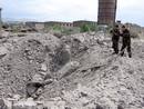 Dos militares georgianos toman im&aacute;genes del agujero que ha dejado una bomba lanzada desde un avi&oacute;n en la ciudad de Gori (Georgia).