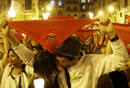 Una pareja se besa en la Plaza de Constituci&oacute;n en el acto que pone punto y final a los Sanfermines.