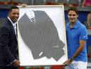 Federer of Switzerland and Will Smith pose with a suit Smith wore in the movie 