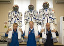 Lalibert&eacute; posa junto al cosmonauta ruso Maxim Surayev (L) y el astronauta americano Jeffrey Williams, sus compa&ntilde;eros de viaje, con sus respectivos trajes espaciales
