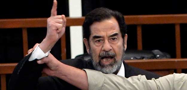 Former Iraqi President Saddam Hussein yells in court as he receives verdict, as bailiff attempts to silence him, during trial in Baghdad