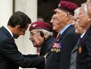 Nicol&aacute;s Sarkozy dialoga con uno de los veteranos de la Segunda Guerra Mundial presentes en el acto.