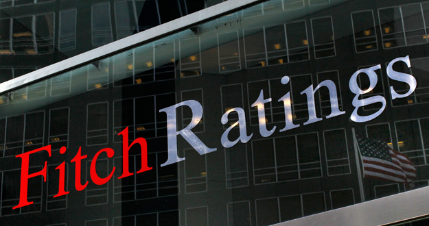 A flag is reflected on the window of the Fitch Ratings headquarters in New York