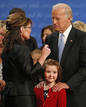 El senador Biden habla con Palin mientras tiene un gesto cari&ntilde;oso con la hija de su rival
