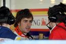 Fernando Alonso intercambia impresiones con sus t&eacute;cnicos en el box de Renault.