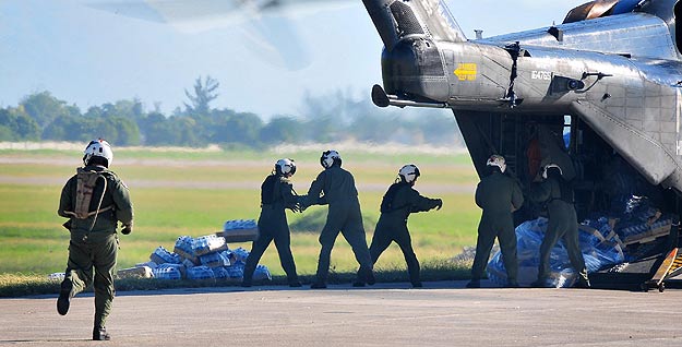 Soldados estadounidense descargan alimentos y suministros de un helicóptero de la Marina en Puerto Príncipe. Soldados estadounidense descargan alimentos y suministros de un helicóptero de la Marina en Puerto Príncipe.