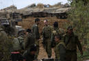 Soldados israel&iacute;es esperan junto a veh&iacute;culos pesados junto a la Franja de Gaza.