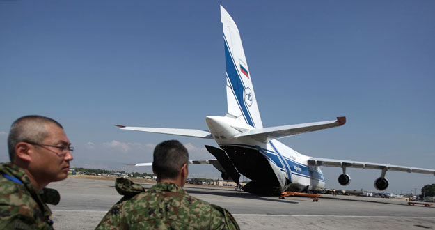 Soldados japoneses observan la llegada de un avi&oacute;n Antonov, cargado de ayuda humanitaria, al aeropuerto de Puerto Pr&iacute;ncipe.