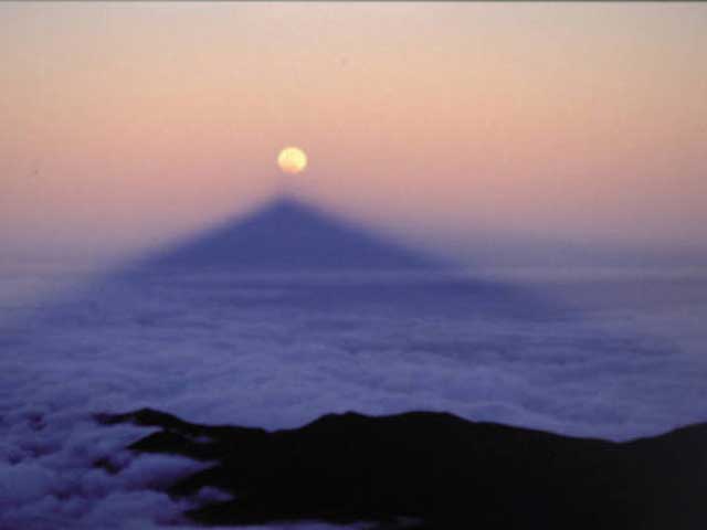 Cuando el eclipse lunar se produce al amanecer o al atardecer, la sombra del Teide se alinea con la Luna.
