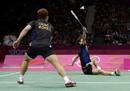 South Koreas Lee Yong-dae returns a shot while sitting on the court as his teammate Chung Jae-sung looks on during their mens doubles badminton semifinal match against Denmark at the London 2012 Olympic Games at the Wembley Arena