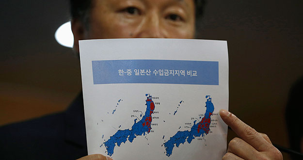 El viceministro surcoreano de Asuntos Marítimos y Pesca, Son Jae-hak, muestra en un documento las prefecturas japonesas de las zonas prohibiciones de importación (en rojo) impuestas por Corea del Sur y China, respectivamente.