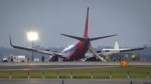 El Boeing 737 de Southwest Airlines se encuentra posado en la pista del aeropuerto de LaGuardia, después de hacer un aterrizaje de emergencia sin su tren de aterrizaje.