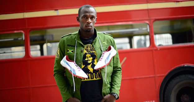 Sprinter Usain Bolt of Jamaica poses during a photo shoot beside a traditional routemaster bus in London