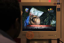 Un periodista observa las imágenes del cuerpo sin vida del líder tamil, Vellupillai Prabhakaran, emitias por una televisión. Un periodista observa las imágenes del cuerpo sin vida del líder tamil, Vellupillai Prabhakaran, emitias por una televisión.