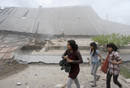 Students run near a collapsed university building after an earthquake hit Padang, on Indonesias Sumatra island