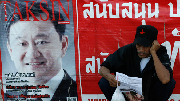 Un partidario del ex ministro Thaksin, junto a un cartel electoral.