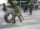 Soldados tailandeses mueven llantas para hacer una barricada en las afueras de la sede del Gobierno en Bangkok.