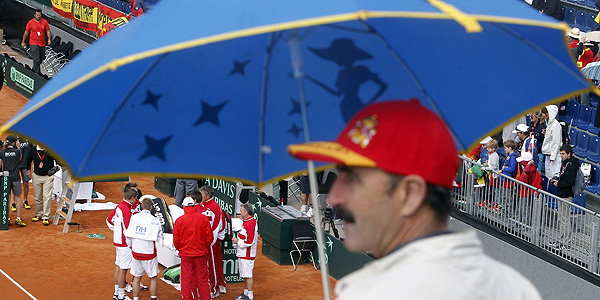 Los tenistas austr&iacute;acos esperan a que amaine la lluvia durante el partido de dobles.