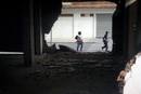 Dos personas caminan junto a los da&ntilde;os materiales causados en un edificio del barrio de San Diego.