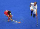 Teun de Nooijer de el equipo holand&eacute;s (R) salta para evitar la pelota del jugador Lee Seungil de Corea del Sur durante el partido de hockey masculino del Grupo B.