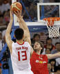 El jugador chino Yao Ming lanza la pelota ante el bloqueo del espa&ntilde;ol Pau Gasol.
