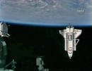 El transbordador espacial Endeavour visto con la tierra en el fondo y parte de la Estaci&oacute;n Espacial Internacional