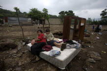 A woman and her son rest on a bed after their home was destroyed by a landslide in Amatitilan A woman and her son rest on a bed after their home was destroyed by a landslide in Amatitilan