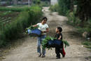 Dos ni&ntilde;os transportan verduras tras dejar el campo al acabar el d&iacute;a en Tecpan (Guatemala).