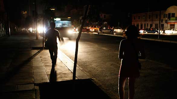 Varias personas esperan el autob&uacute;s en la ciudad chilena de Vina del Mar completamente a oscuras