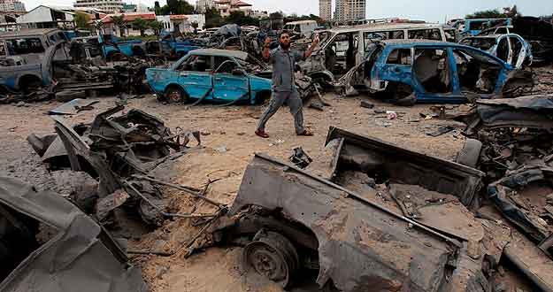 Varios palestinos inspeccionan la zona de seguridad de Ham&aacute;s destruida tras un ataque a&eacute;reo israel&iacute;.
