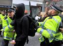 Varios polic&iacute;as empujan a un activista que participaba en una concentraci&oacute;n en el distrito financiero de la capital brit&aacute;nica