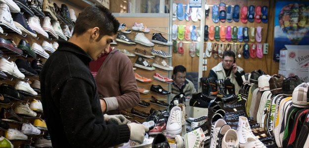 Customers look at shoes in a shop in Tehran's Grand Bazaar
