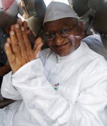 El veterano activista social indio Anna Hazare saluda desde un coche tras ser detenido en Nueva Delhi