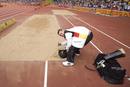 Wojtek se lleva de recuerdo arena de la pista tras ganar la prueba masculina de salto de longitud de categor&iacute;a F42