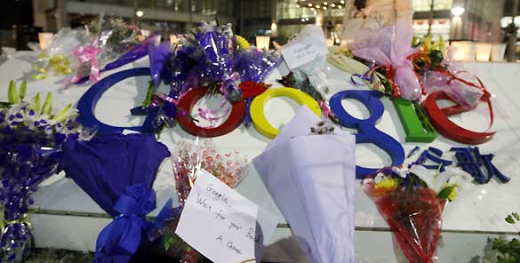 Una mujer lee los mensajes dejados junto a los ramos de flores en la sede de Google en Pek&iacute;n, tras la amenaza de la compa&ntilde;&iacute;a de abandonar el pa&iacute;s por la censura.