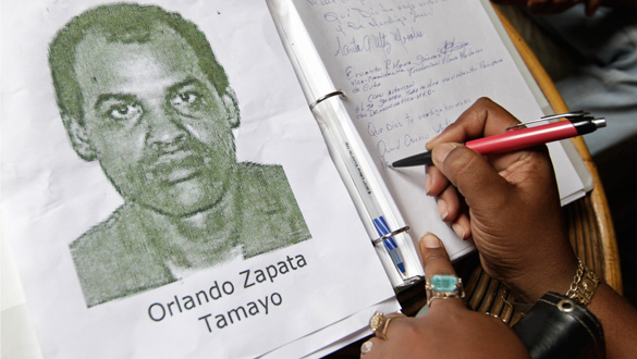 Una mujer firma en el libro de condolencias de Orlando Zapata.
