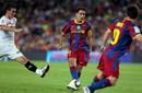 Xavi Hern&aacute;ndez dando un pase para el delantero argentino Lionel Messi.