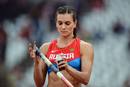 La rusa Yelena Isinbayeva poniendo spray adhesivo en su p&eacute;rtiga antes de empezar la prueba.