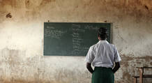 A young girl reads the day's lessons at a school in Mozambique