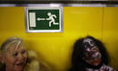 A woman looks at a man dressed like a zombie at a subway station in Madrid